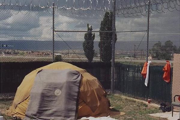 Prison yard with sweat lodge in corner of yard.