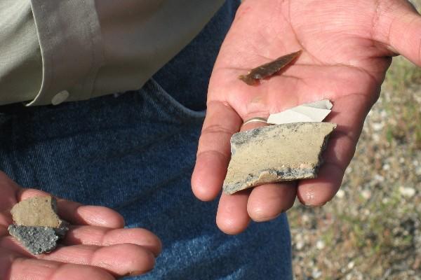 Land steward holding shards of pottery in hands.