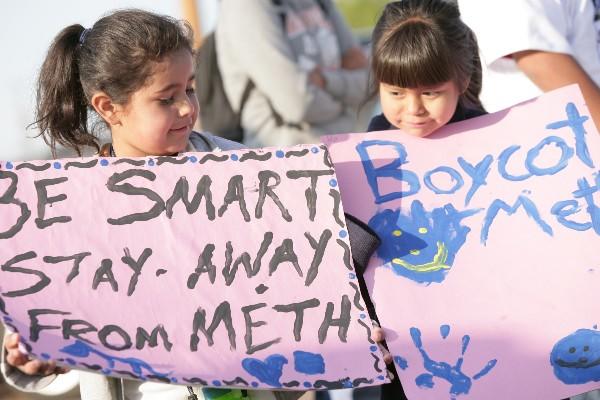 Two children holding signs advocating against meth use.